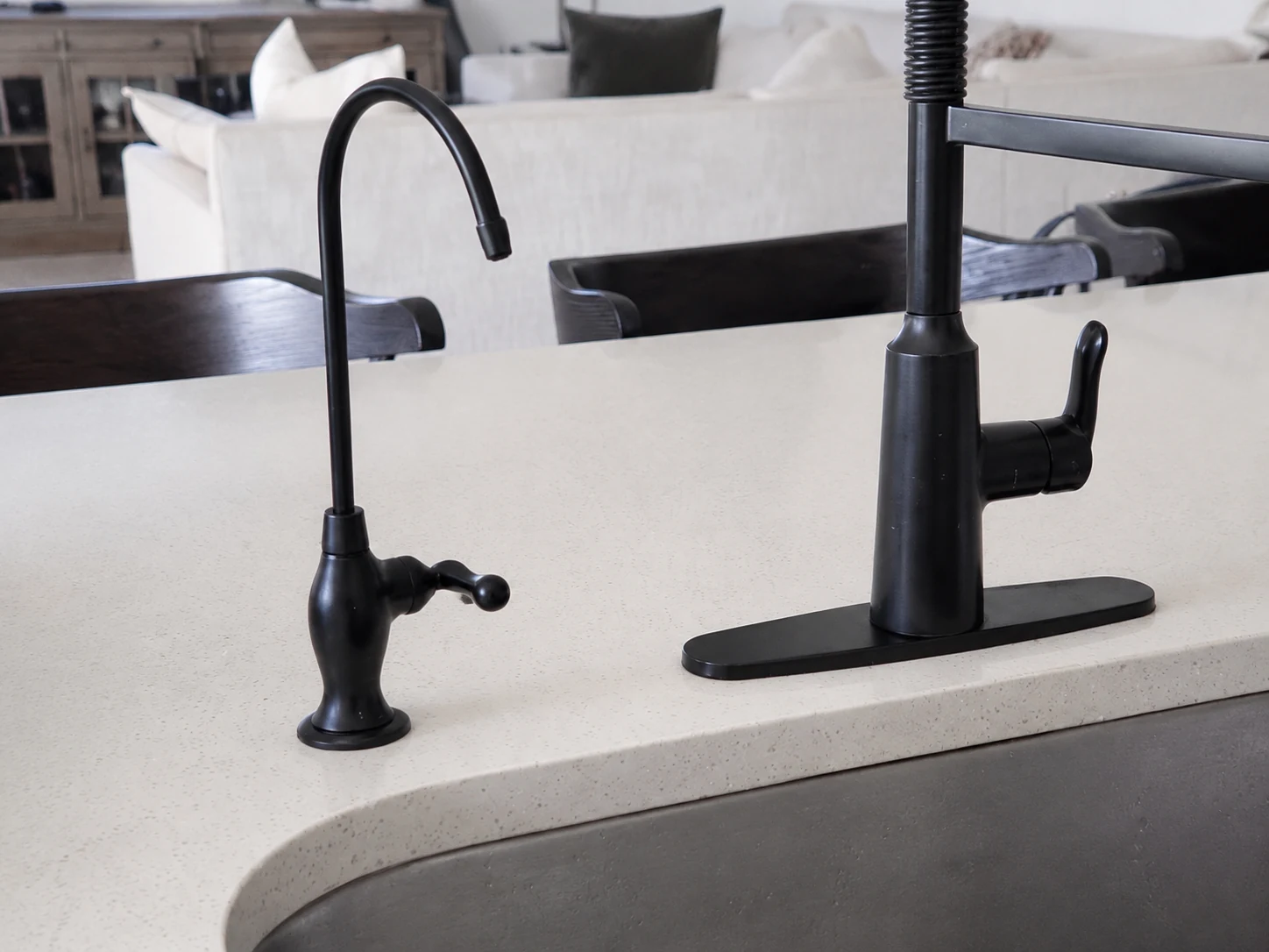 A black HydroSip drinking-water faucet next to the customer’s existing kitchen faucet